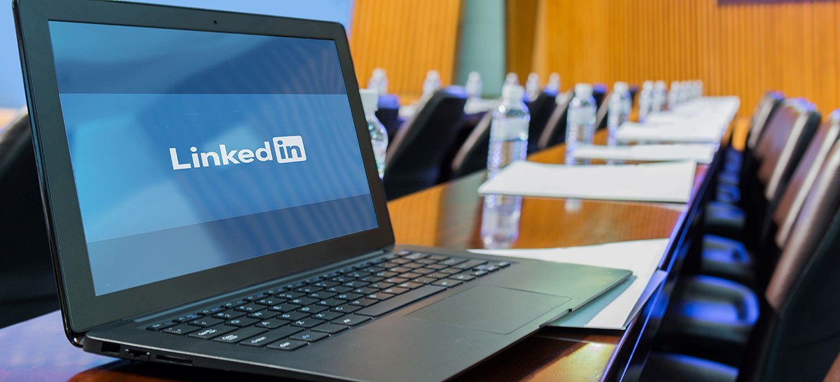 Laptop displaying LinkedIn in corporate boardroom