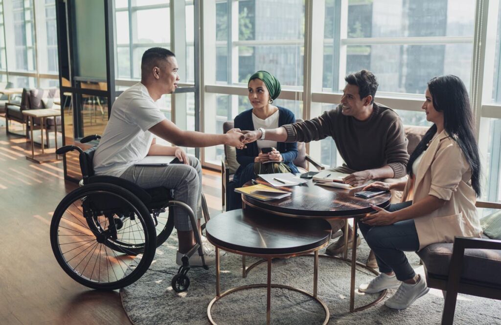 An inclusive team of four Generaion Z office workers around a conference table. 